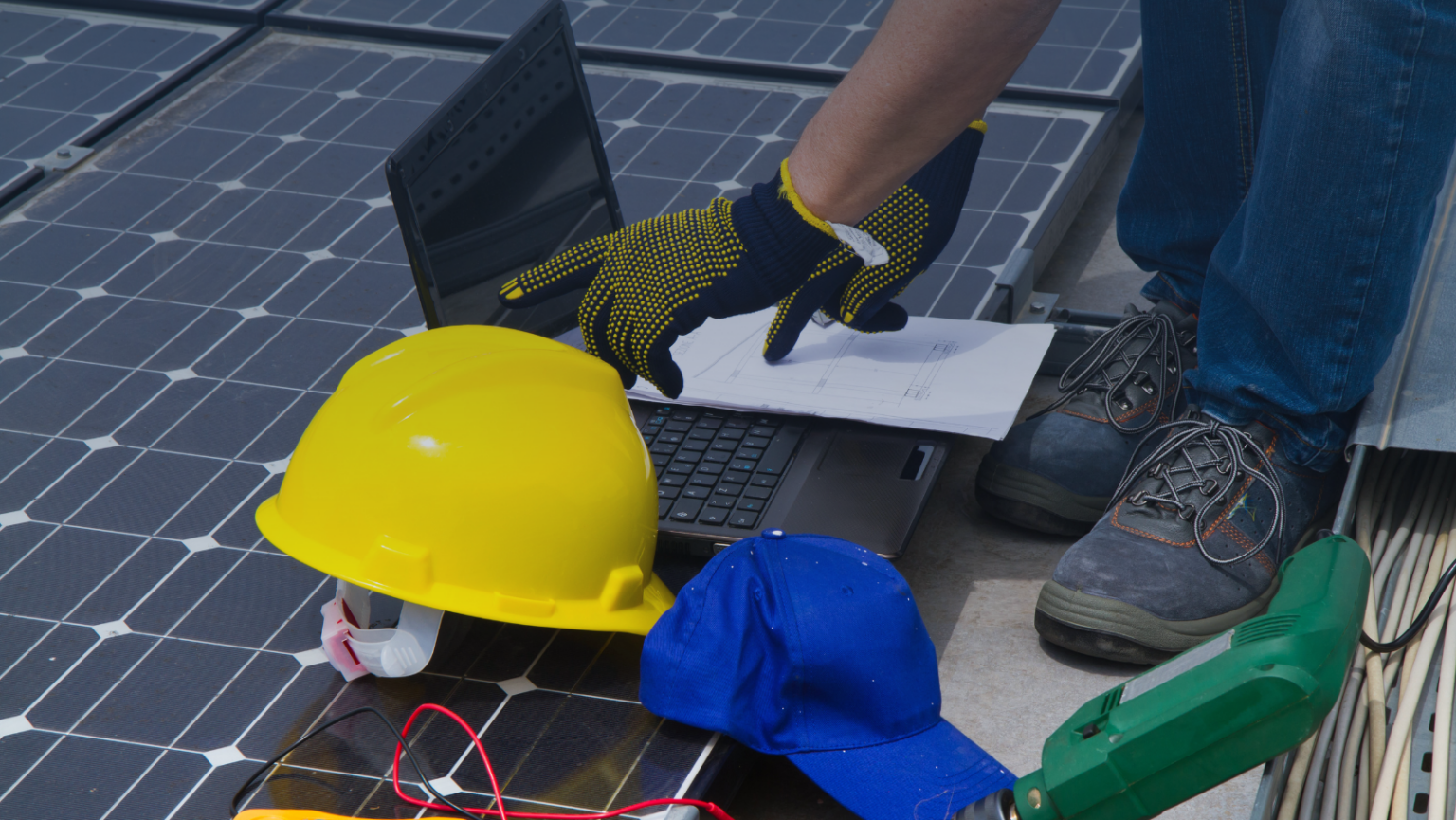 Individual engaged with a laptop next to a solar panel, highlighting the integration of technology and renewable energy.