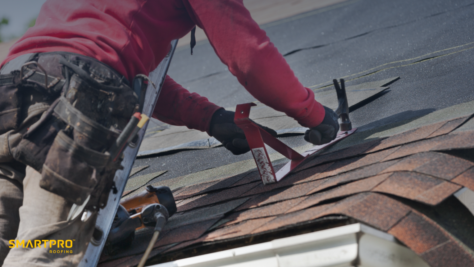 A man on a roof uses a tool while selecting appropriate roofing materials for the project