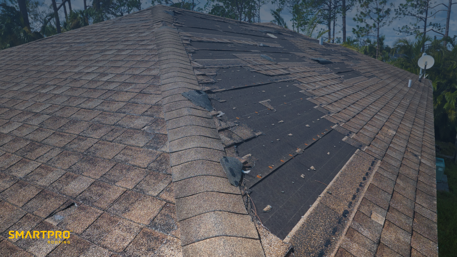 Damaged roof shingles with visible wear, branded with SmartPRO Roofing logo