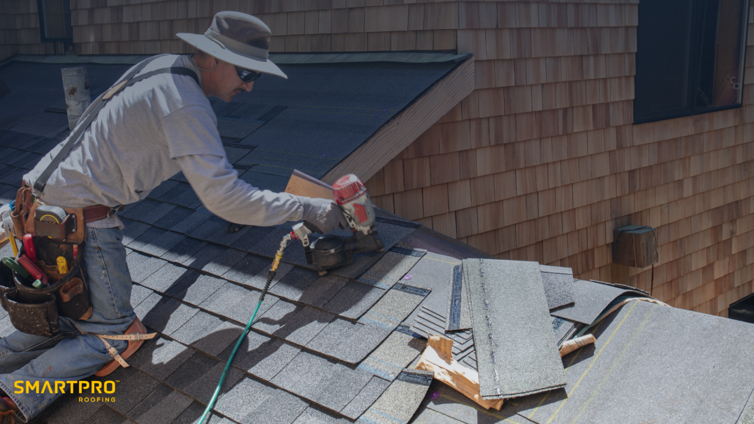 A man engaged in roofing work, skillfully using a hammer to secure materials on the rooftop.