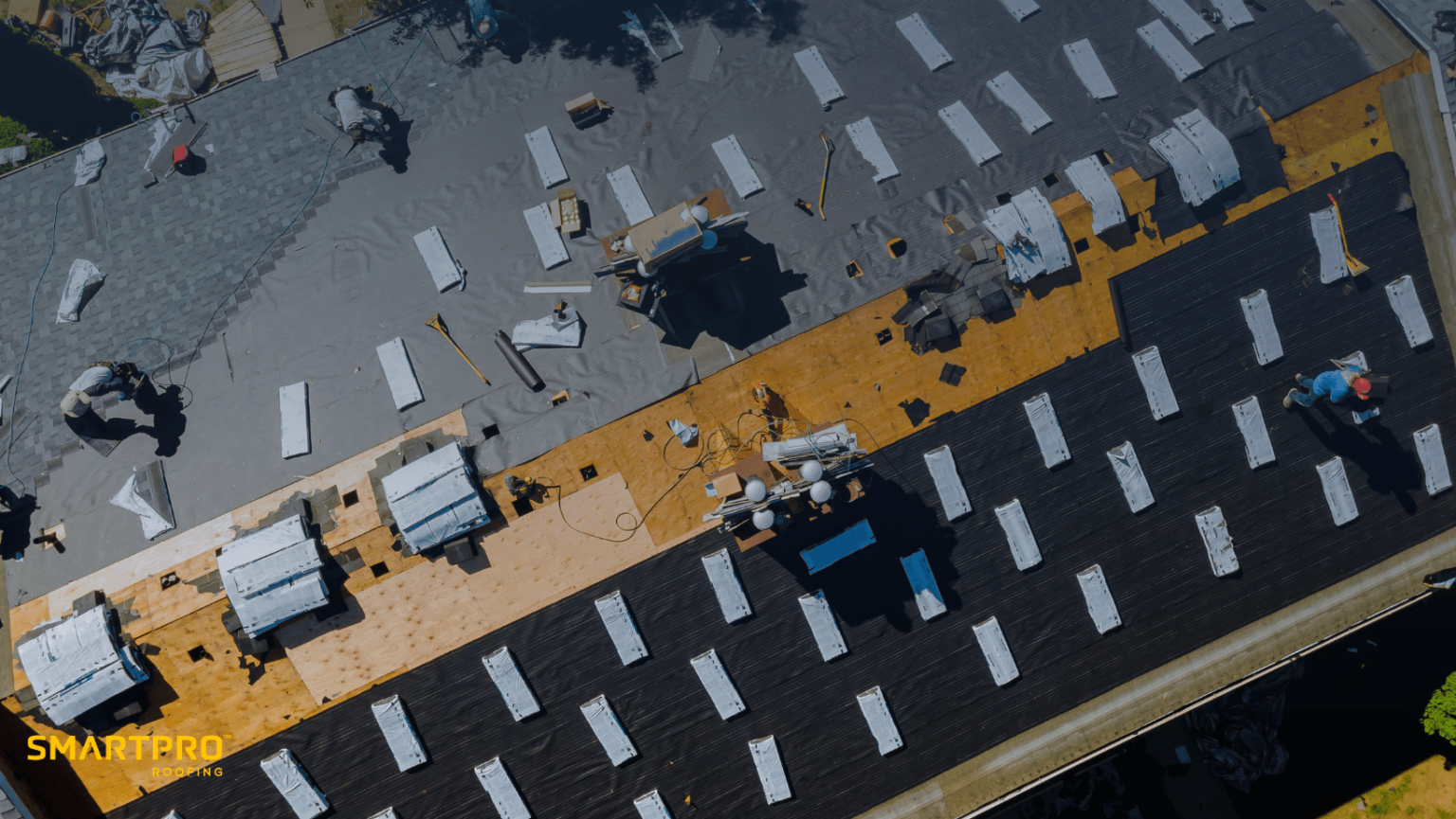 Overhead view of a roof under construction, featuring workers engaged in a roof replacement project for optimal results.