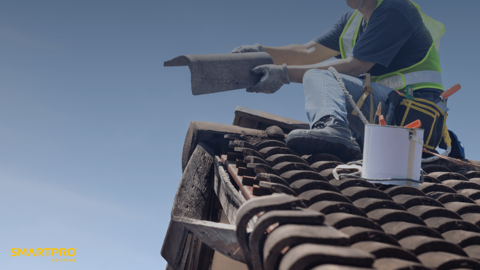 A man using a tool while working on a roof, demonstrating construction or maintenance activities.