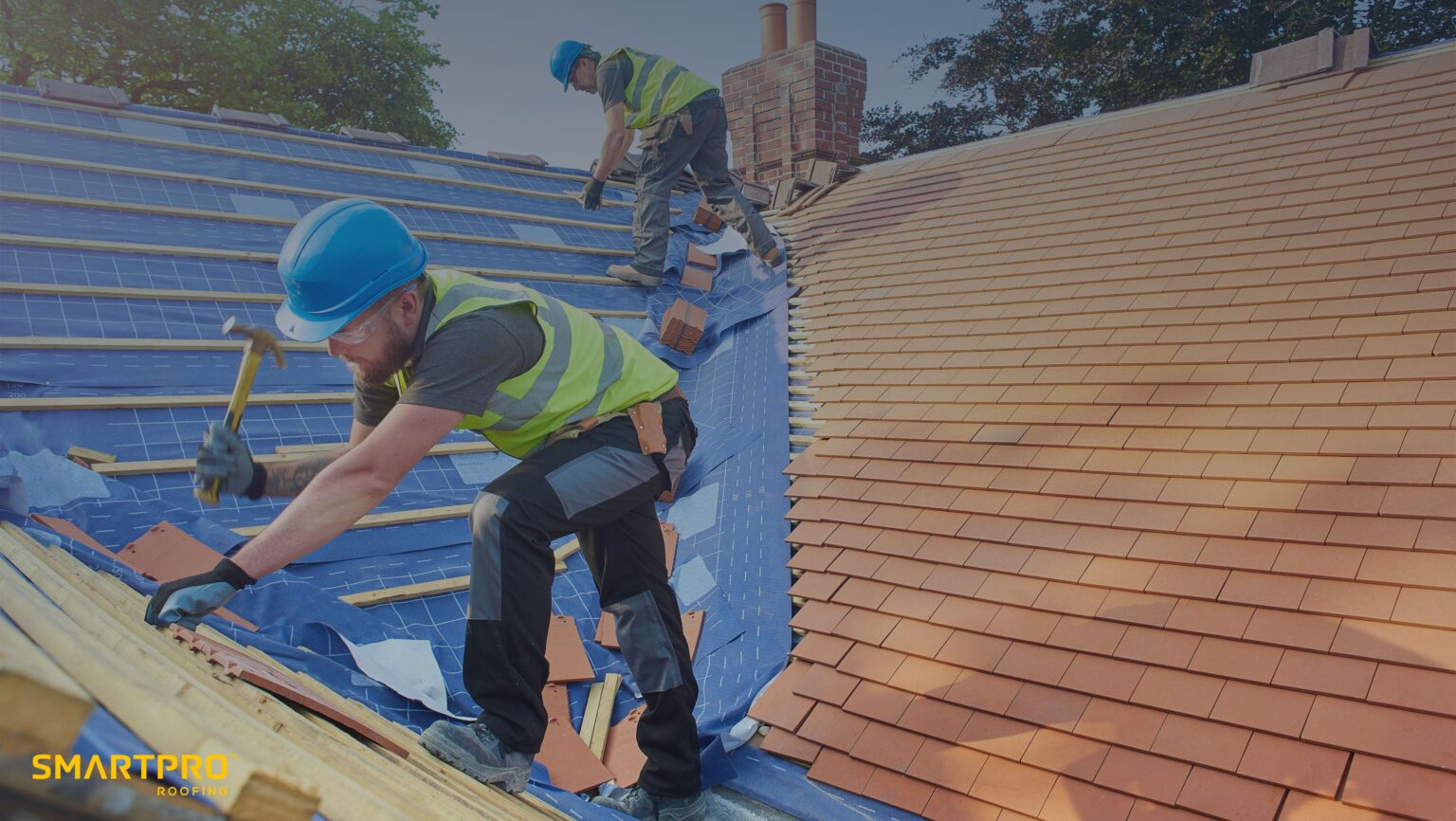 A man is using a hammer to work on a roof, demonstrating construction skills and focus on his task.