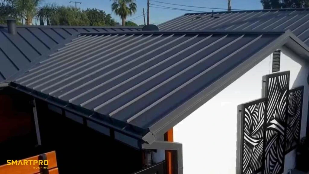 A white house featuring a sleek black metal roof