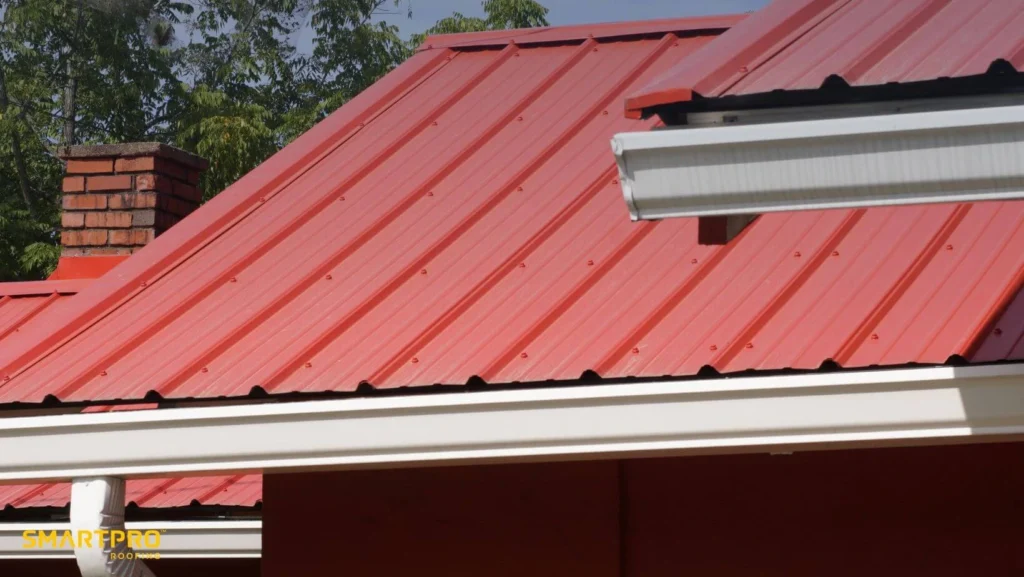 A red roof featuring white trim and a white gutter