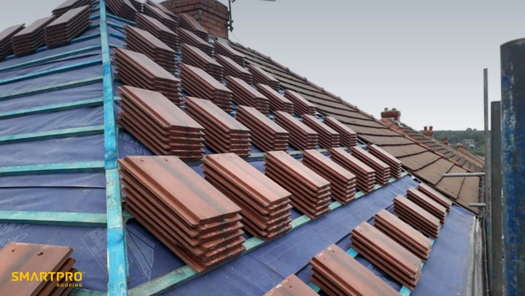Roofing professionals installing shingles on a house, highlighting safety gear and equipment in use.