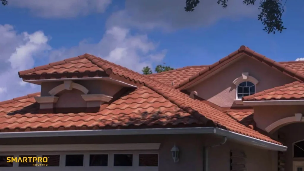 Tile Roof Warranty: What Florida Homeowners Should Know Before Choosing a Roof 12 A house featuring a red tile roof and a white garage, set against a clear blue sky.