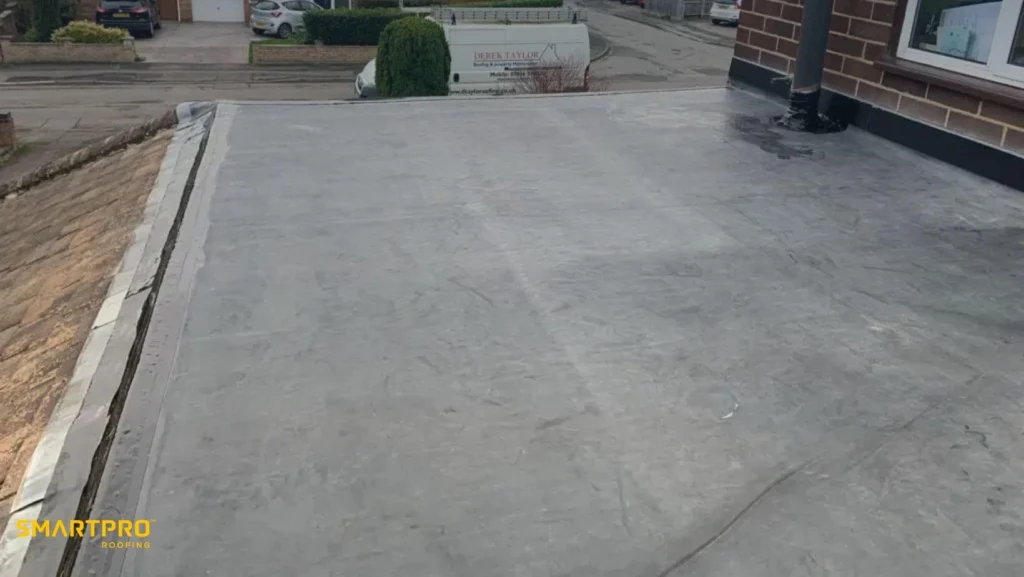 A flat roof covered with a smooth, flat roofing membrane, showcasing its even surface and material texture.